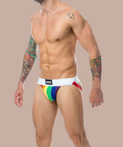 Pleasurements Mob Classic Jock Stripe Rainbow in regenboogkleuren met een witte tailleband gedragen door een model